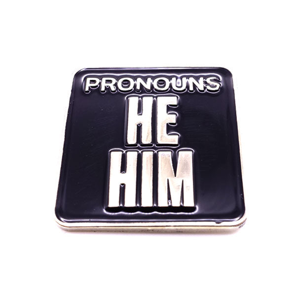 Picture shows frontside of pronouns badge - "Pronouns / He/ Him" silver metal and black enamel